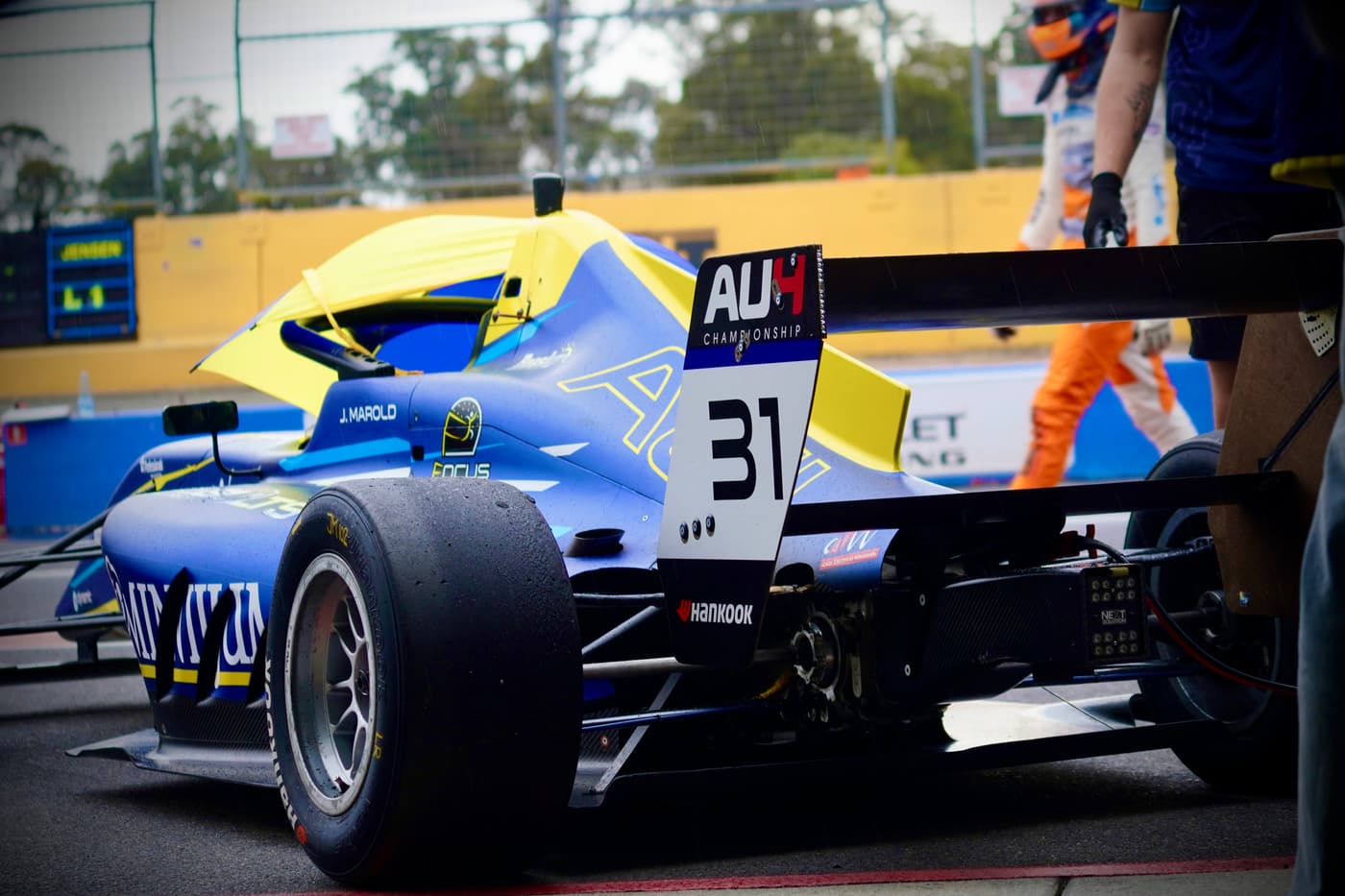 Blue formula car number 31 rolling through pit lane