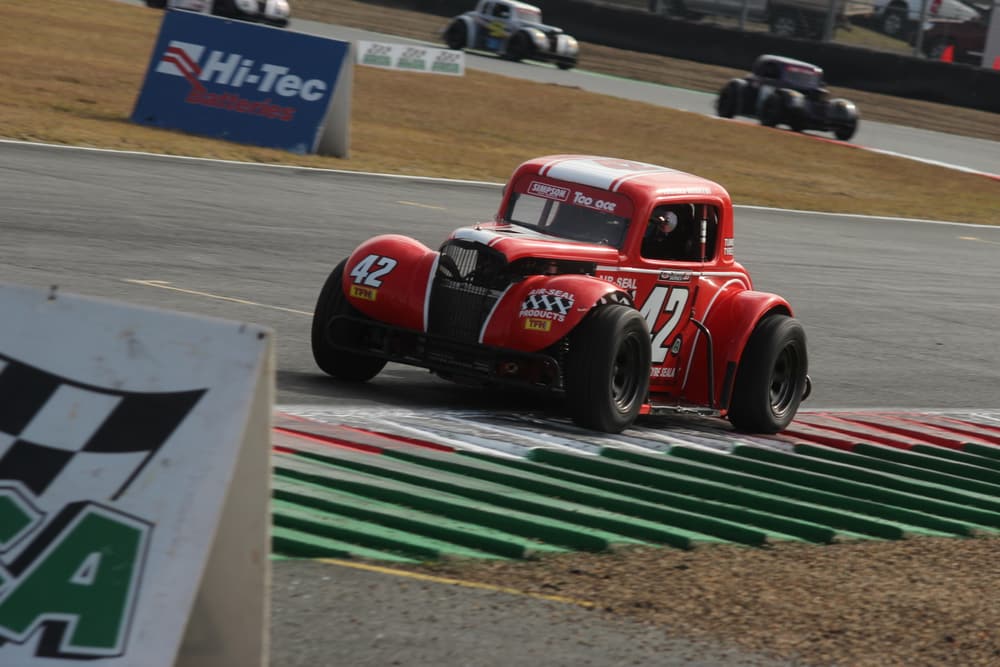 Legend cars battling over a kerb