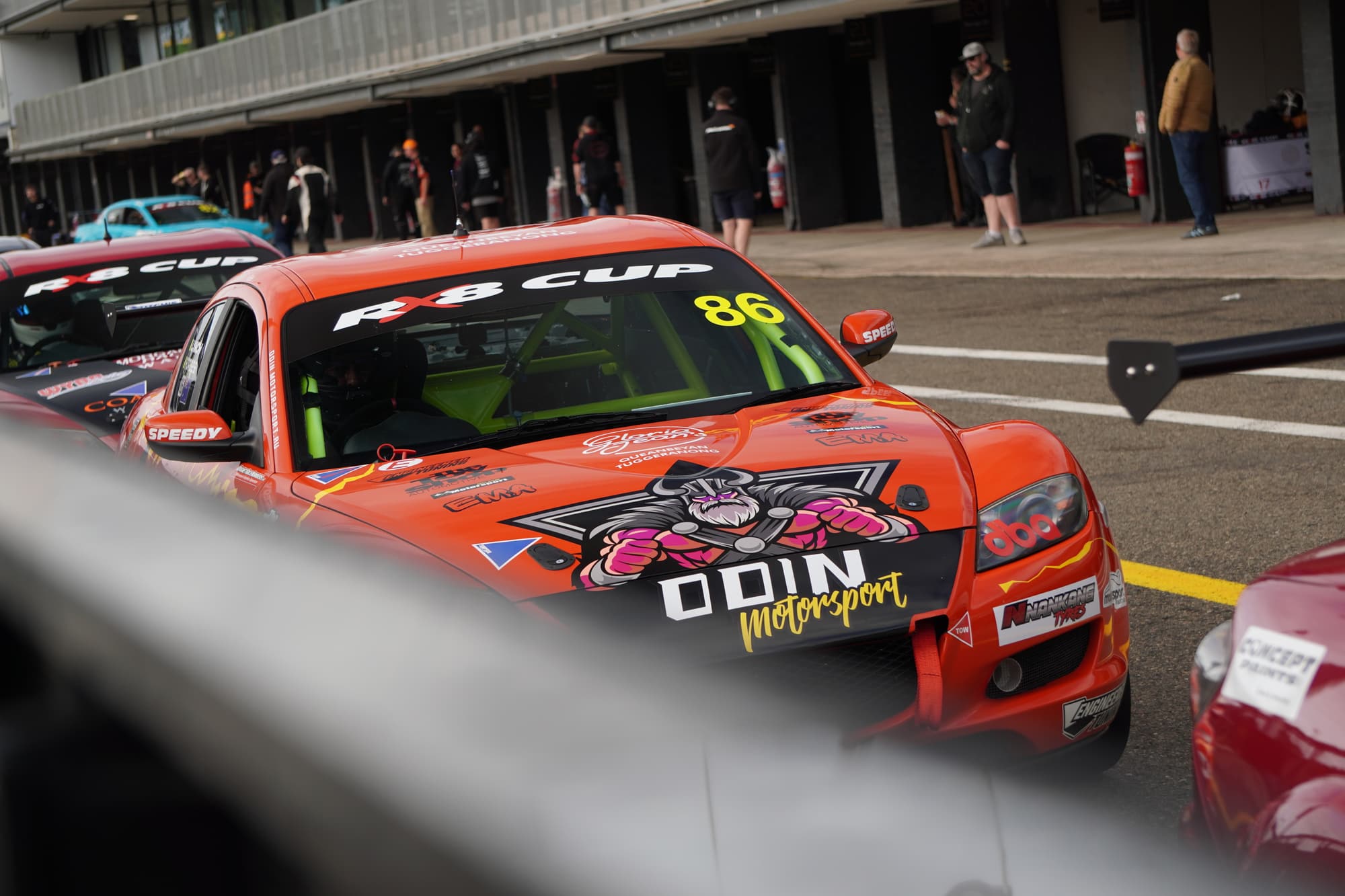 Race cars lined up in pit lane before a session