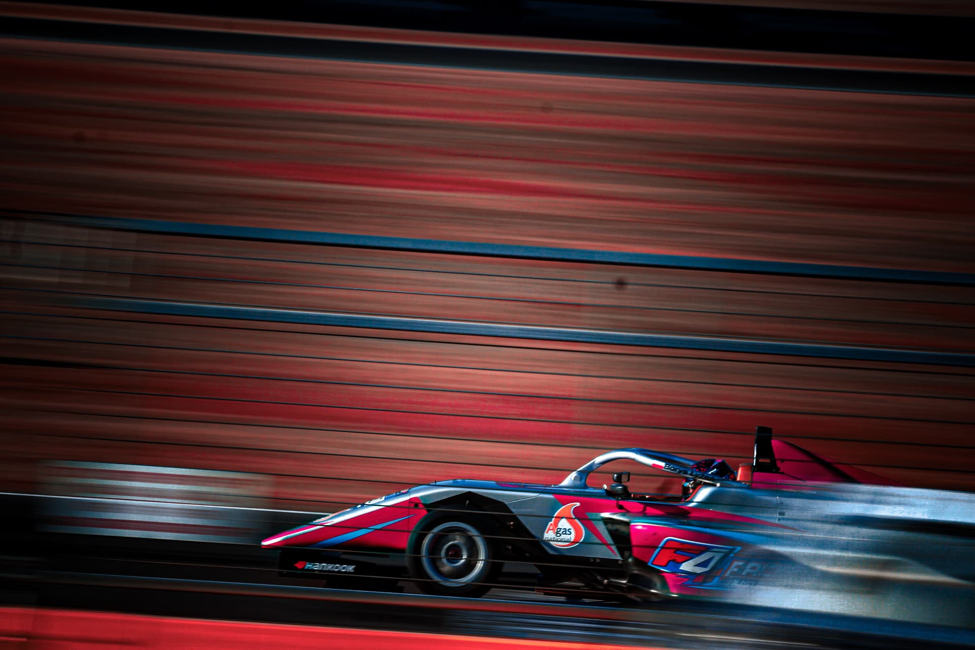 Sports prototype at speed past the pit wall